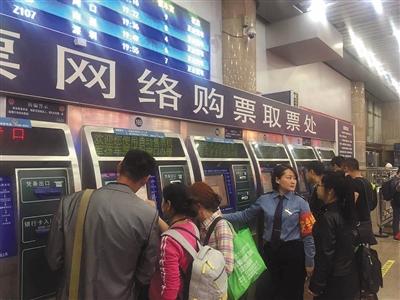 昨日，北京西站，北广场售票处，工作人员正帮助乘客取票。本版图片/新京报记者 王飞 摄