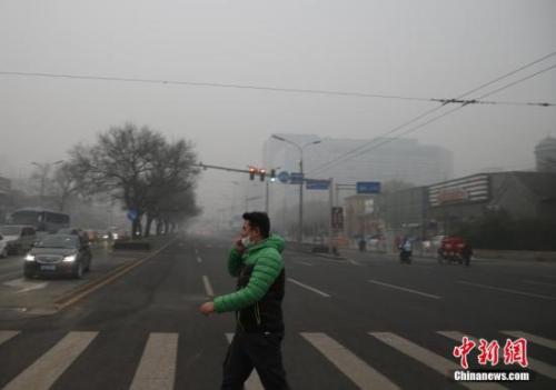 资料图：一名戴着口罩的行人走在北京街头。<a target='_blank' href='http://www.chinanews.com/'>中新社记者 张浩 摄