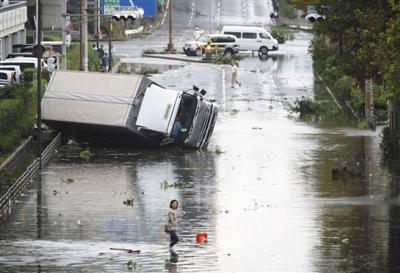 9月4日，在日本大阪，一辆卡车翻倒在地。今年第21号台风“飞燕”4日中午在日本德岛县南部登陆，这是25年来登陆日本的最强台风。新华社/共同社